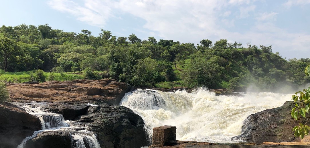 Photographing Murchison Falls: A stunning view of the powerful waterfall cascading through a narrow gorge, surrounded by lush greenery